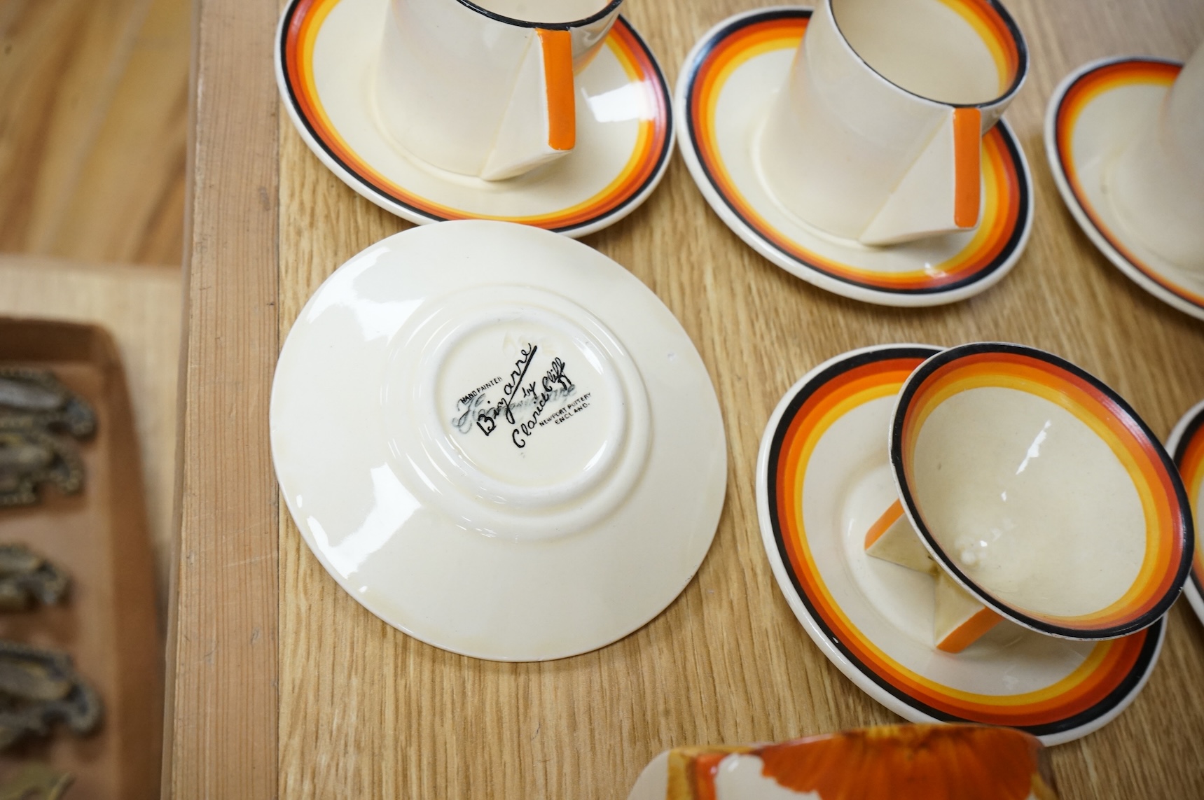 An Art Deco Clarice Cliff Bizarre part coffee set and a similar Rhodanthe-pattern preserve pot and cover, largest 11cm high